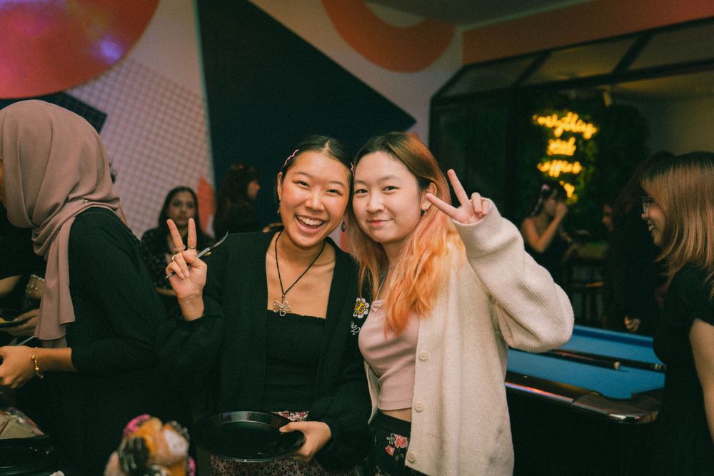 Friends posing together at a party making peace signs.