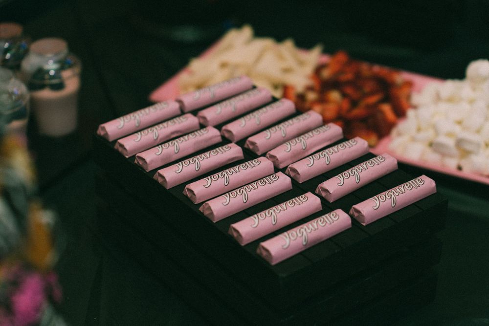 Pink chocolate bars arranged neatly in rows on a dark surface.