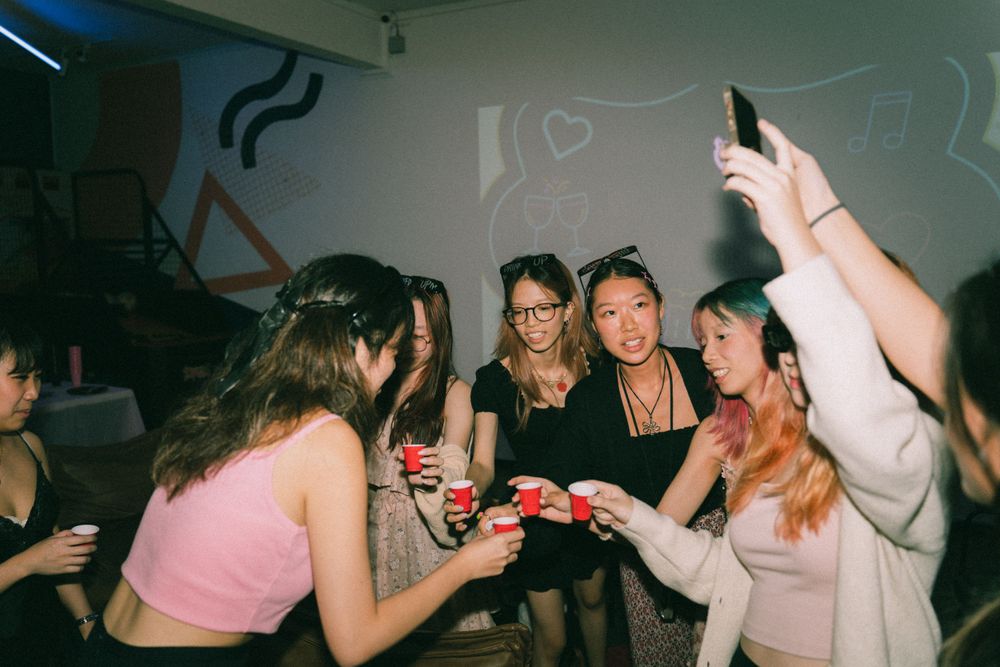 Friends gathered around a table playing games at a party.