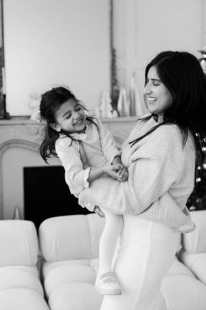 Black and white portrait of playful moments in a cozy living room setting.