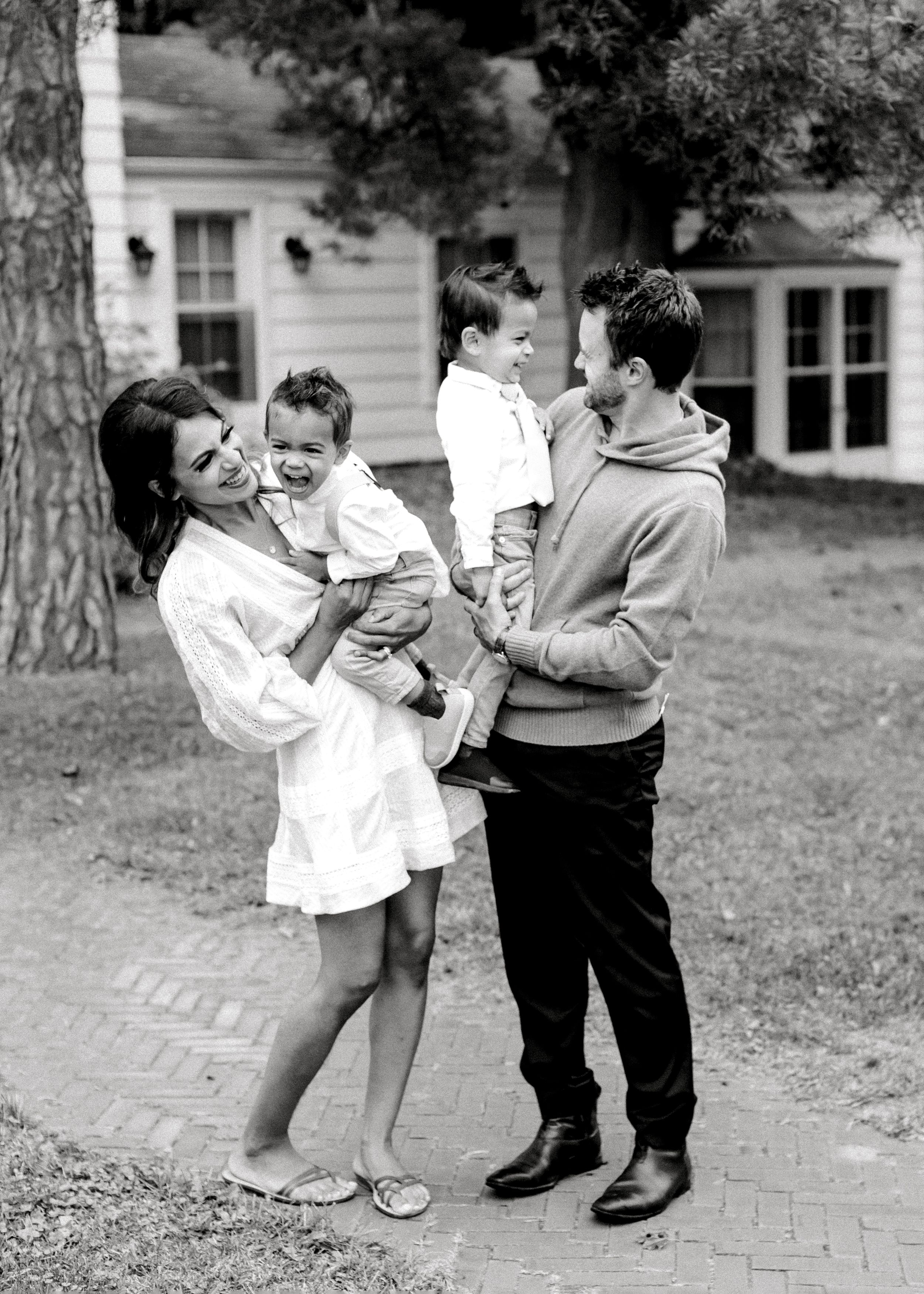 A touching black and white family portrait in front of a classic suburban home.