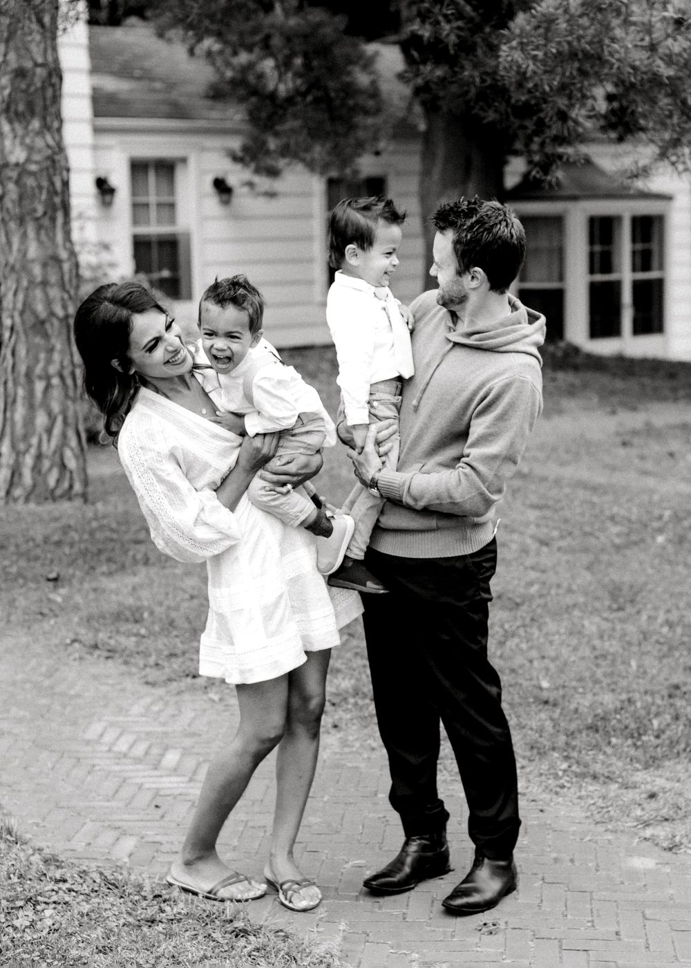 A touching black and white family portrait in front of a classic suburban home.