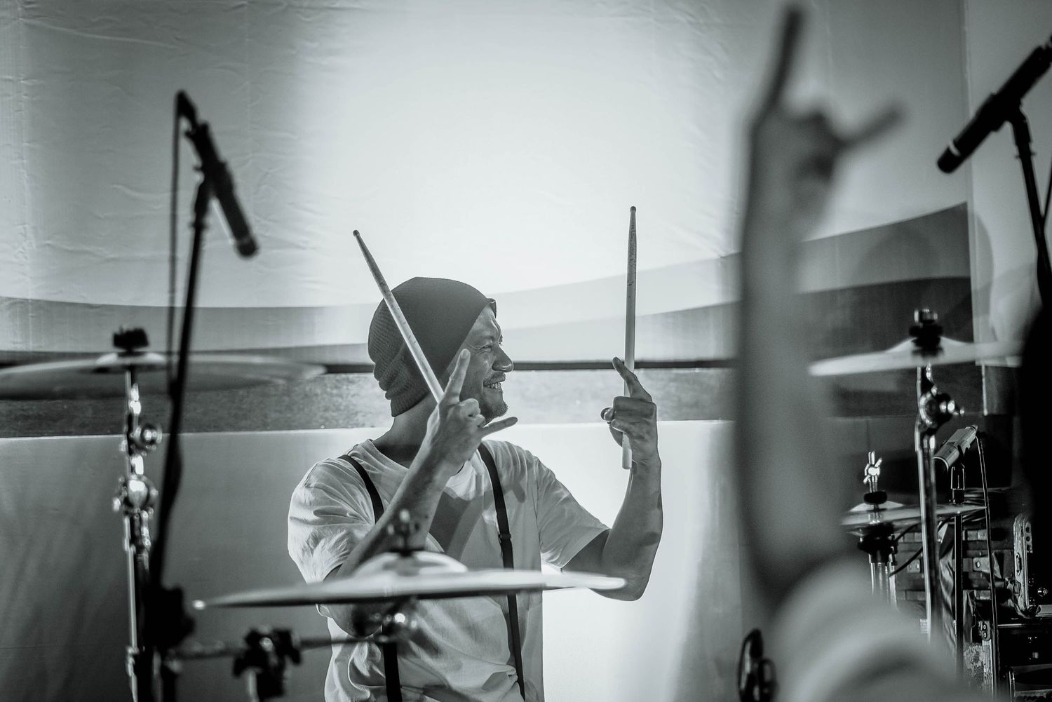 Black and white portrait of drummer performing with intense concentration.