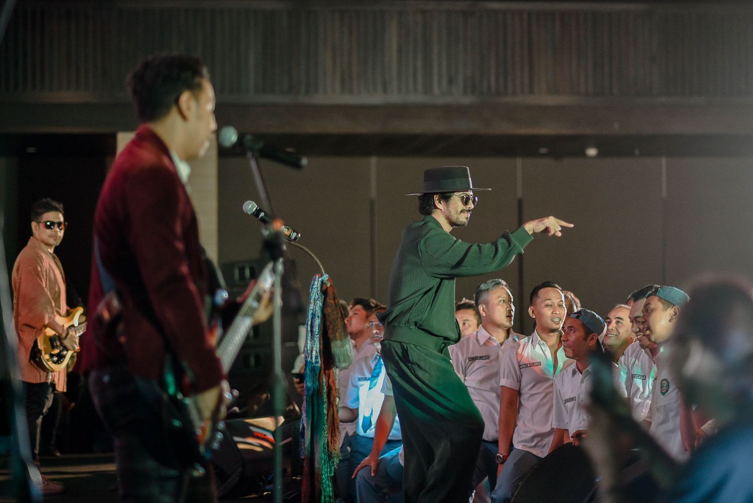 Performers on stage engaging with excited audience during live concert.