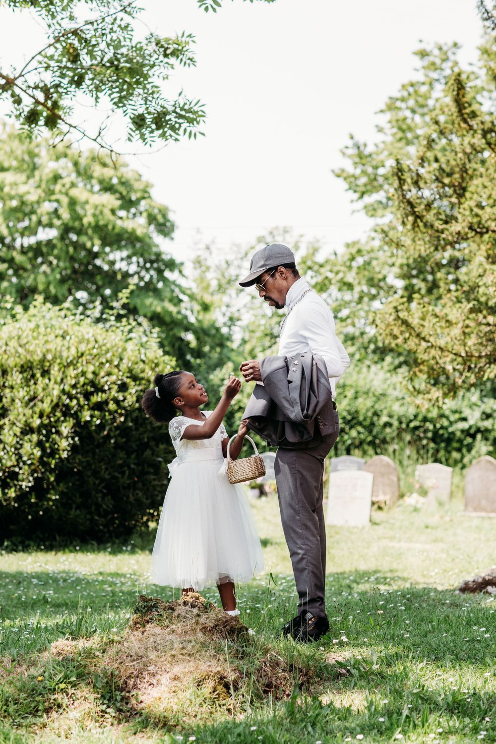 A touching outdoor moment between two people dancing in formal attire on a sunny day.