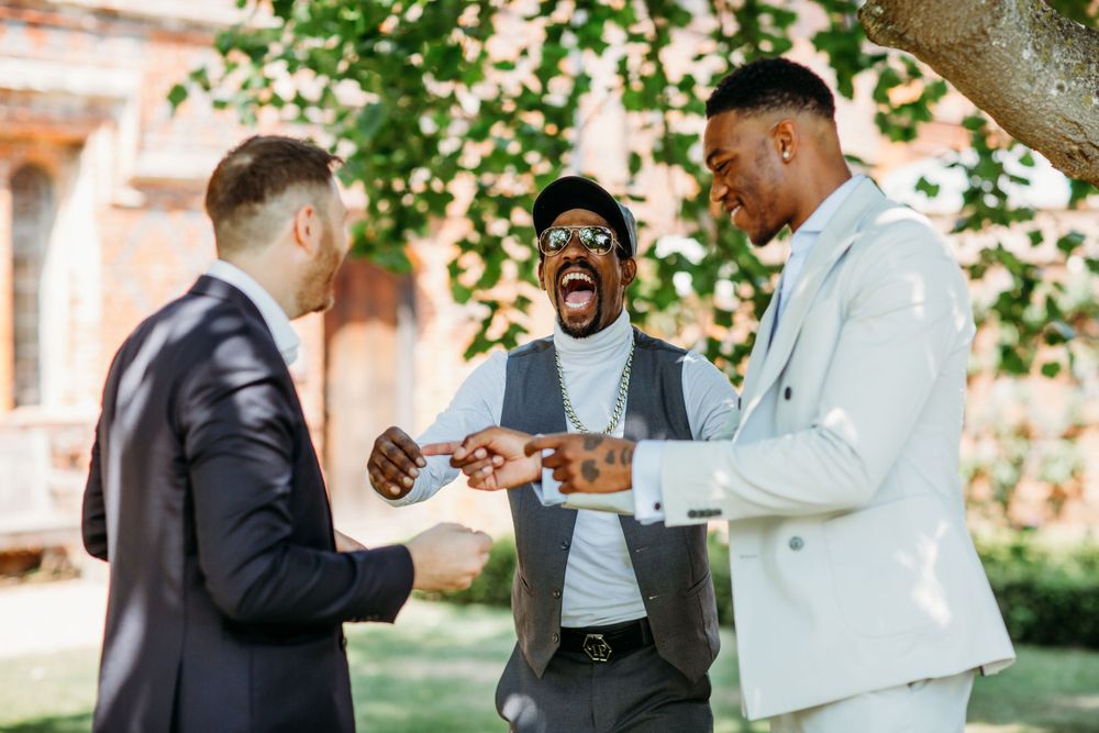 A candid moment between wedding guests during an outdoor celebration.