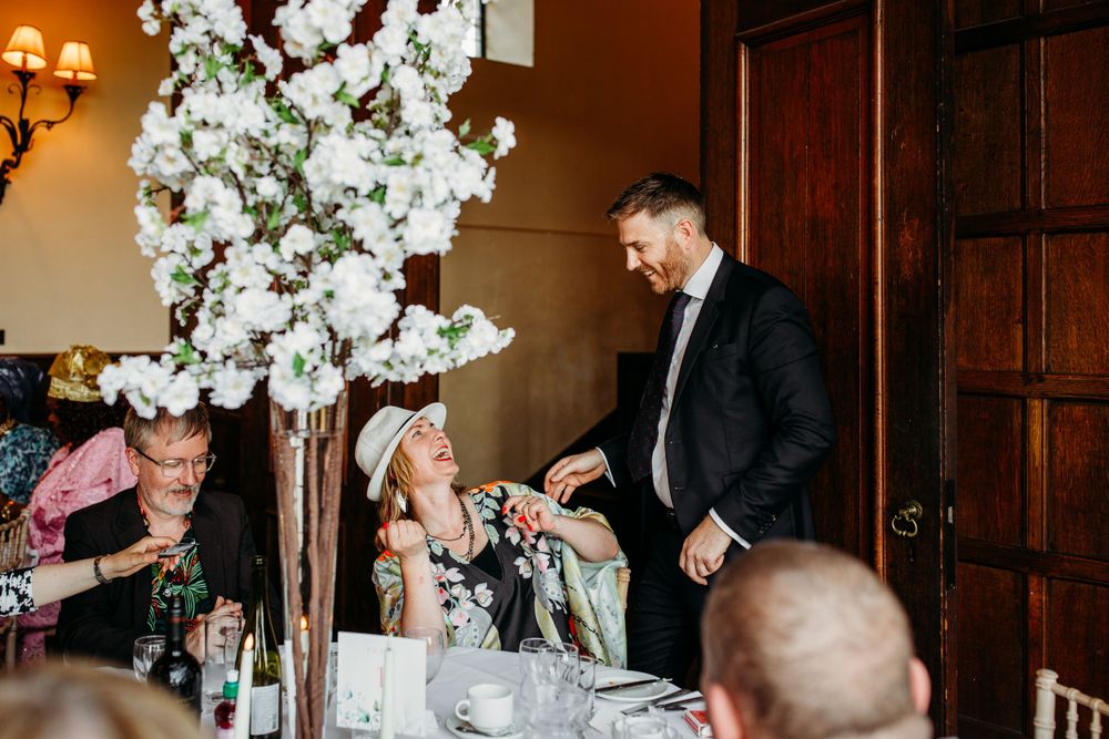 Wedding reception guests celebrate under elegant white floral decorations.