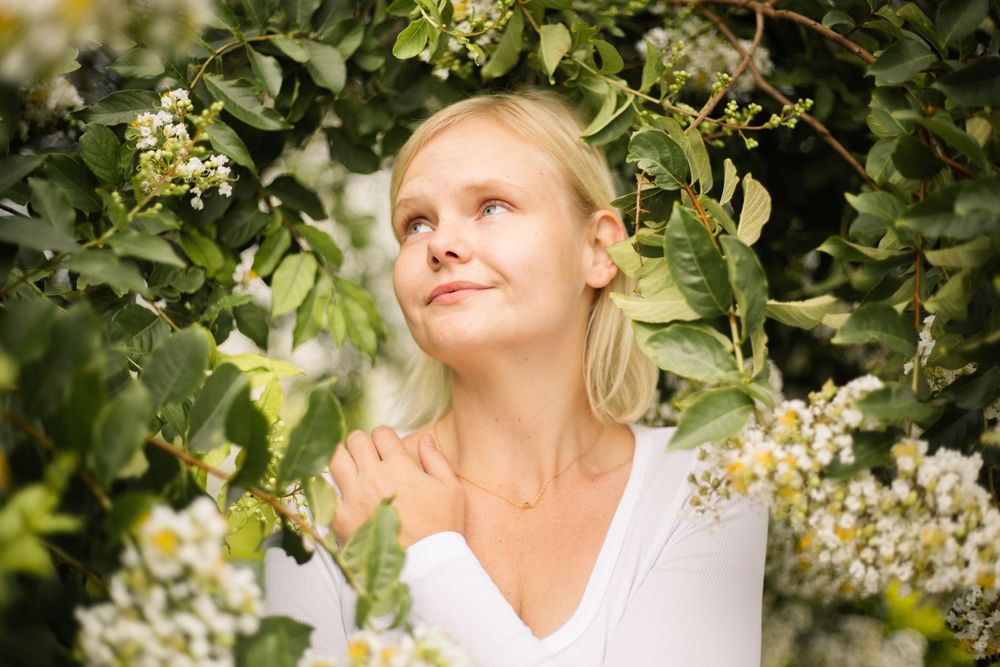 Ethereal garden portrait with soft lighting and blooming white flowers.