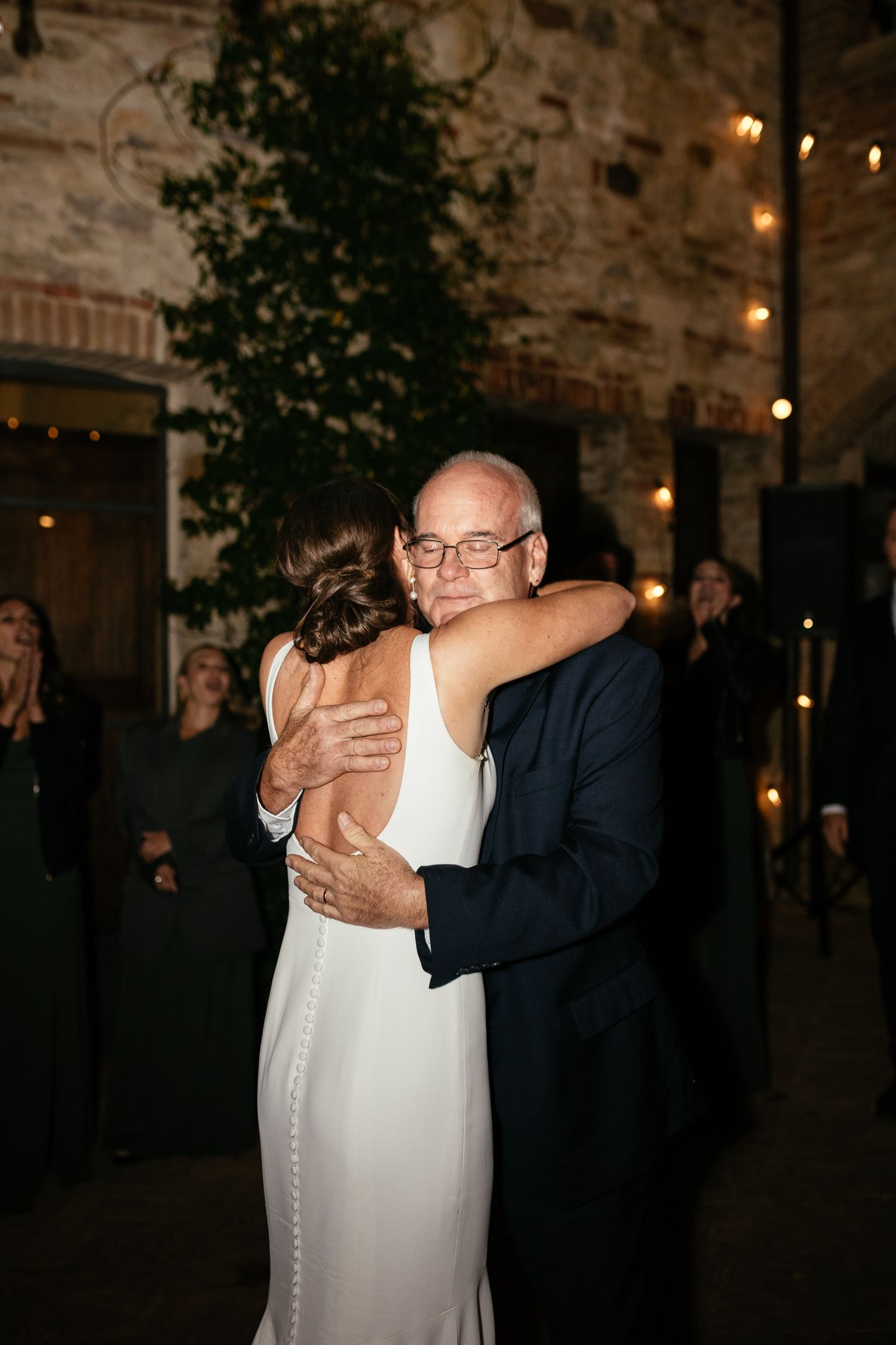 A moment between father and daughter at a wedding in Tuscany.