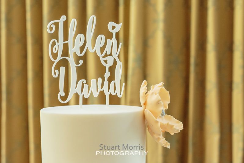 helen and david cake topper sits proudly atop their wedding cake