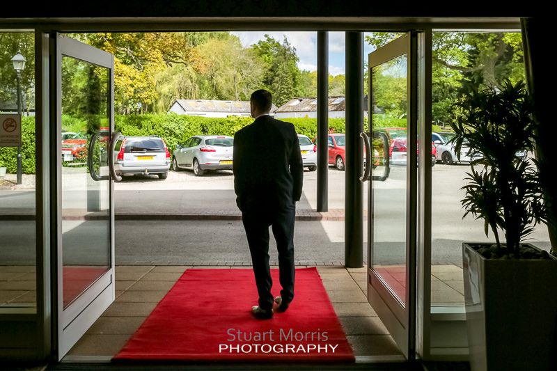 wedding guest waits in the craxton wood doorway on the red carpet for the bride to arrive
