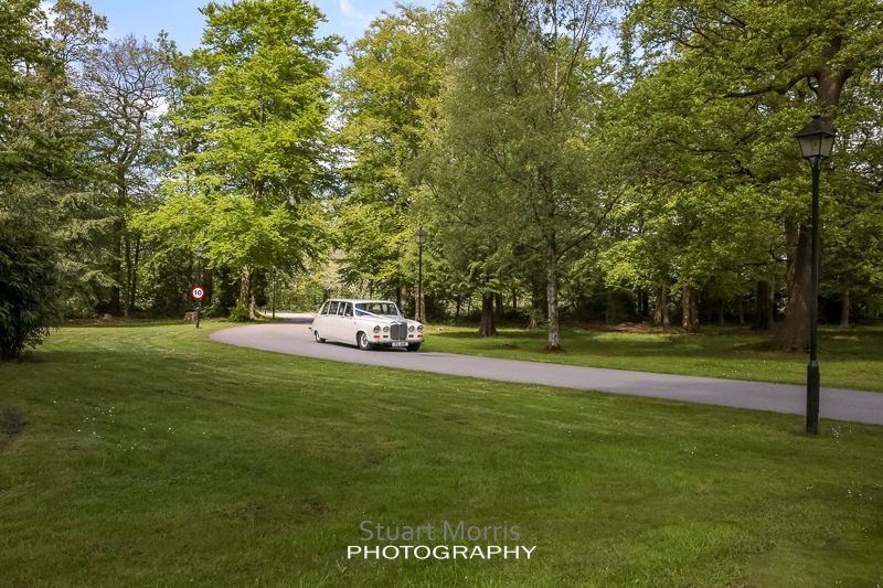 the wedding car makes its way up the craxton wood driveway with the bride