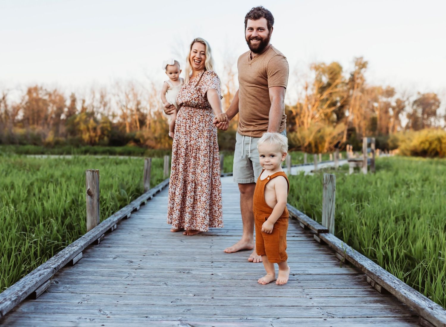 Neutral color pictures of family on boardwalk