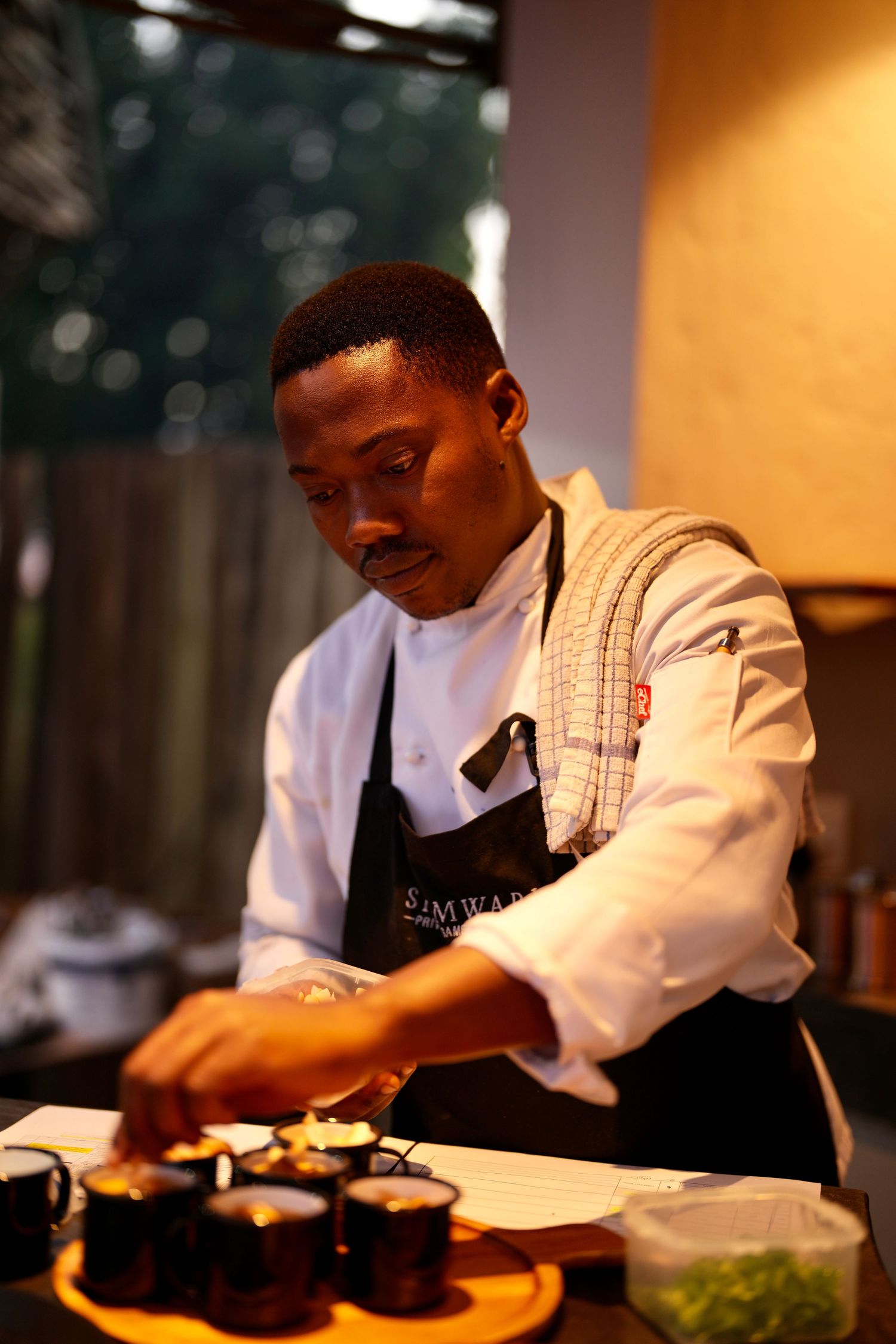 Chef preparing food plates in restaurant kitchen with focused concentration.