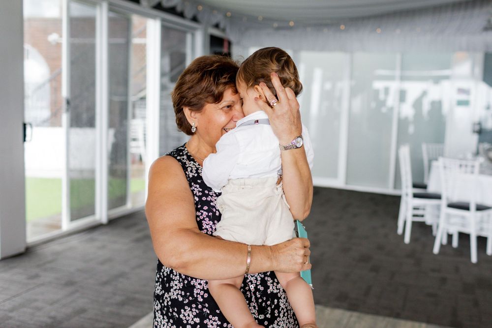 Tender family moment at elegant event venue decorated with white drapes.