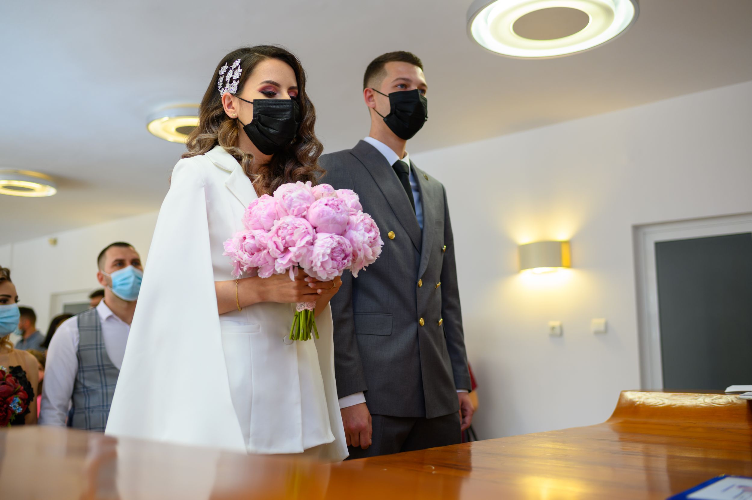 Wedding ceremony in a modern indoor venue with circular ceiling lights.
