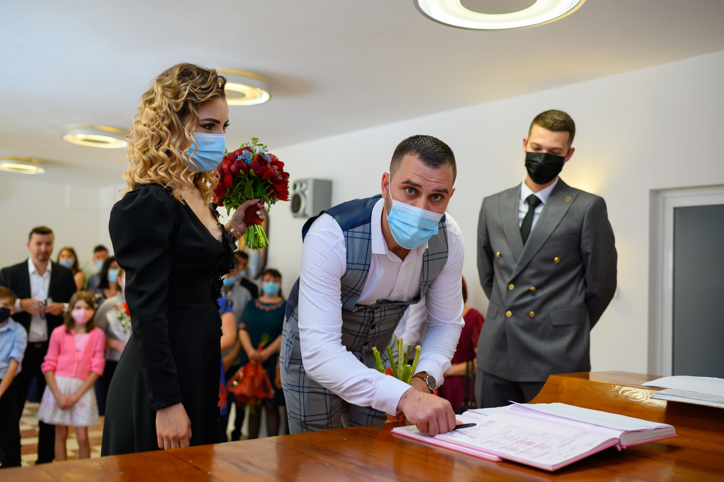 A civil ceremony taking place with attendees wearing face masks during the pandemic.