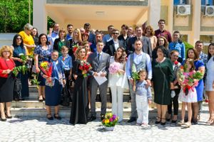 Large group portrait of wedding guests and family members on outdoor steps.