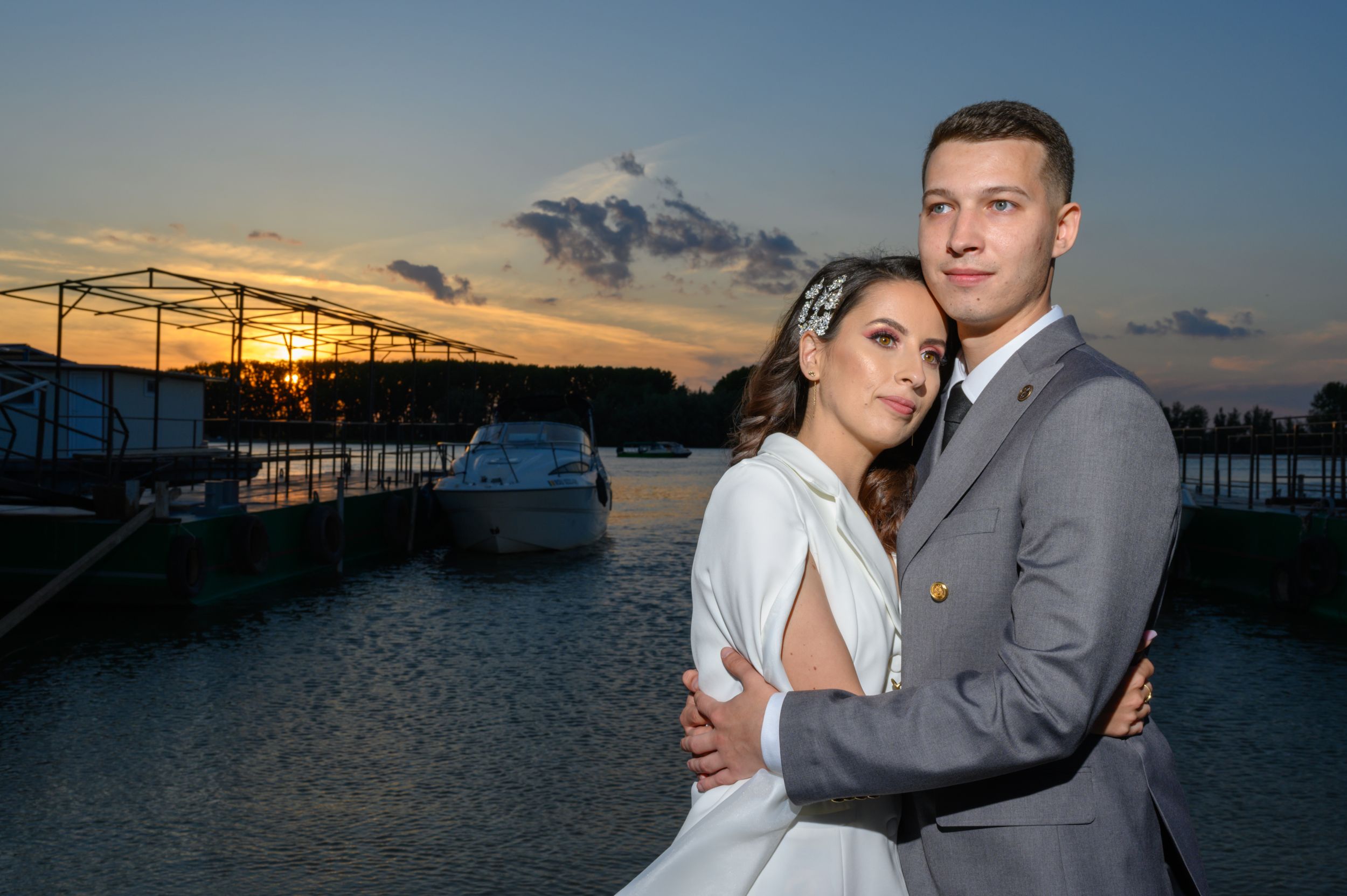 Romantic couple photos at marina during golden hour with boats in background.