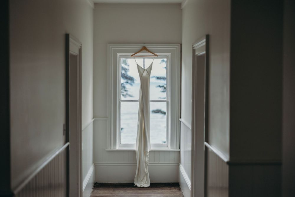 Minimalist hallway interior with white walls and natural light streaming through windows.