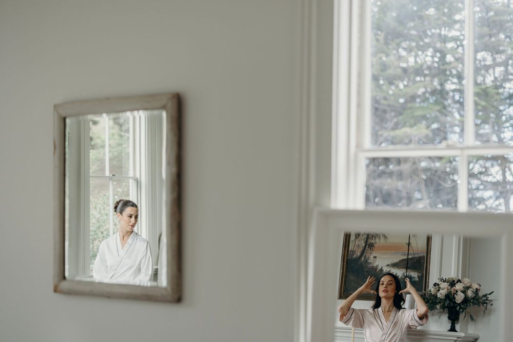 Interior of an elegant white room with multiple windows and framed artwork.