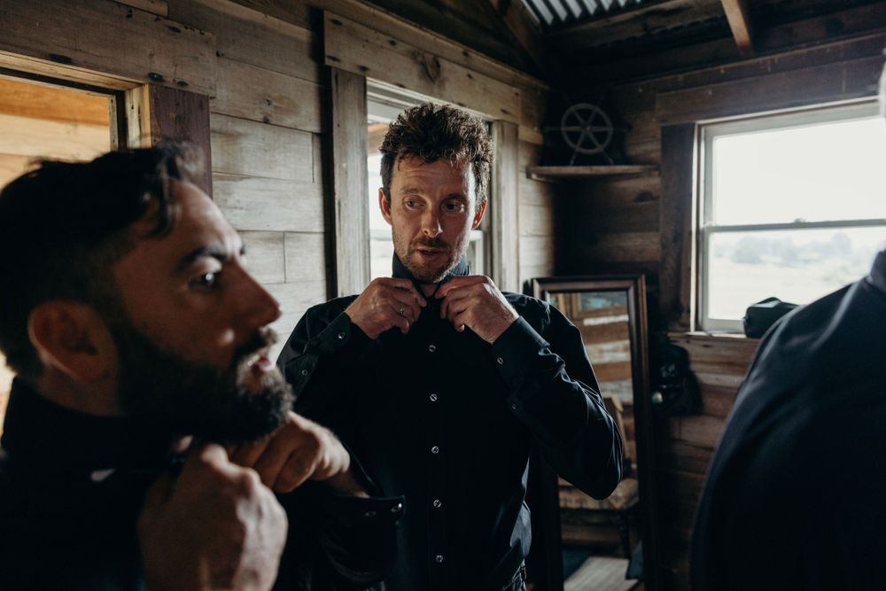 People gathered in a dimly lit rustic cabin with wooden walls.