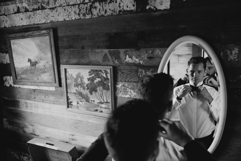 Dark and moody interior of a rustic cabin with framed artwork on wooden walls.