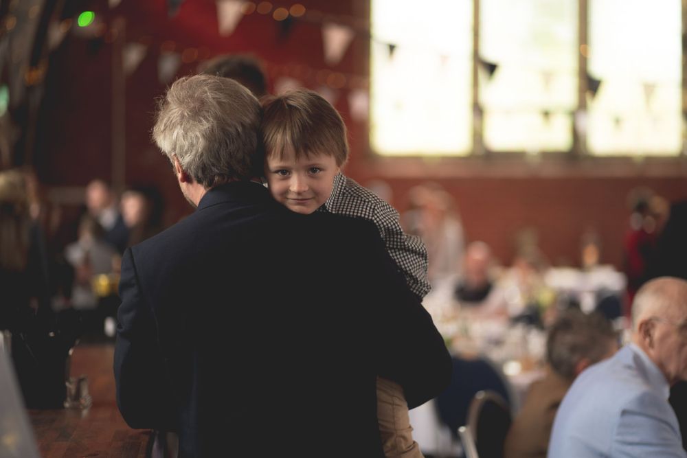 A candid moment captured during a wedding reception showing guests dancing.