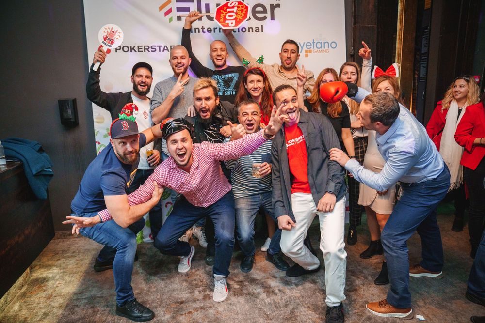 Energetic group poses together making silly faces and gestures at a corporate event.