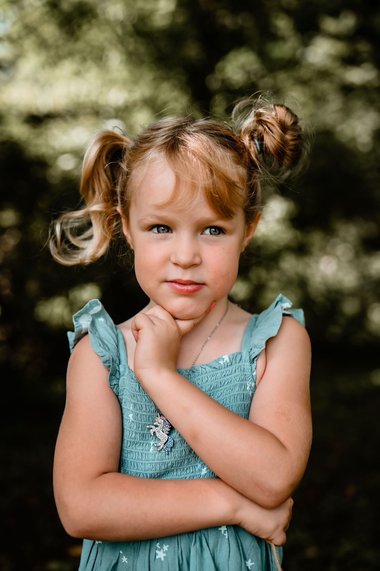 A series of expressive portraits of a young child in a blue dress making playful faces.