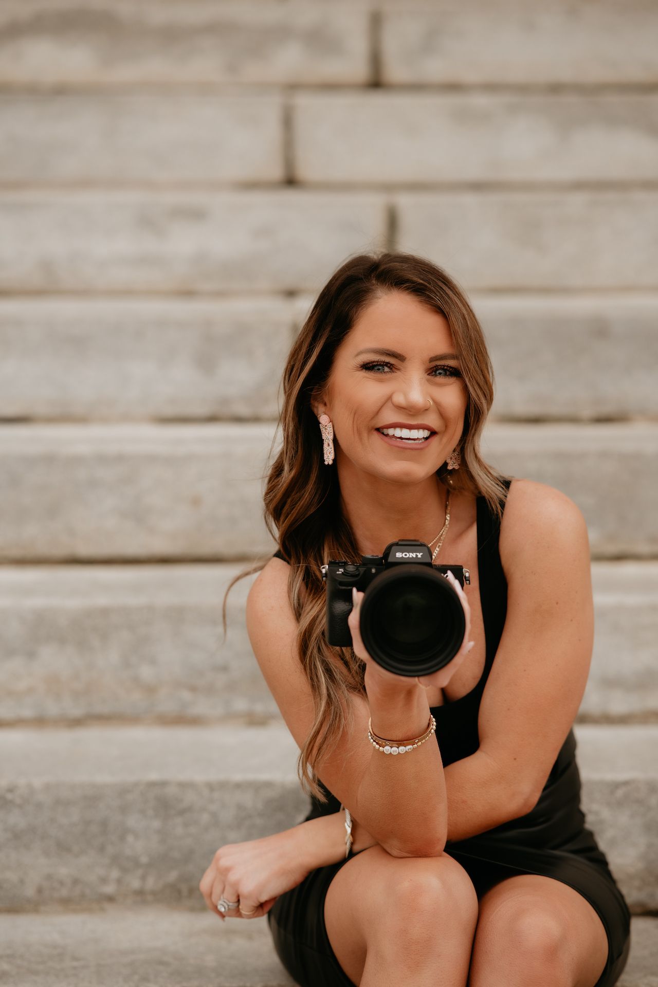 A beautiful woman, the photographer, showing her lens where she makes all her magic.