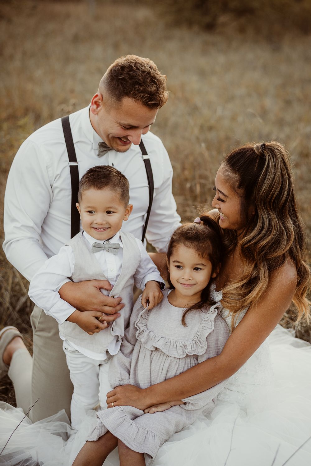 A sweet family portrait shows parents and children sharing joyful moments during wedding celebrations.