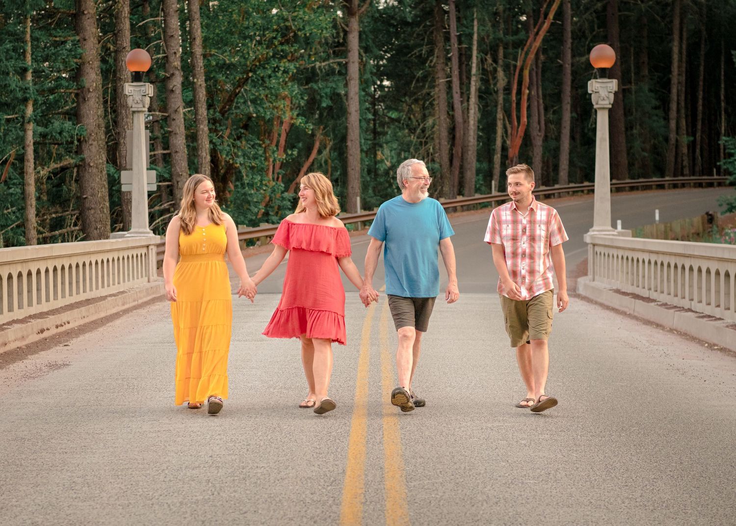 Portrait of family holding hands and walking together on old Historic bridge