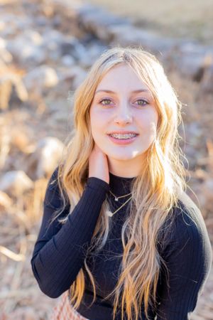Portrait of person in black sweater with long blonde hair in golden sunlight in Springfield, MO.