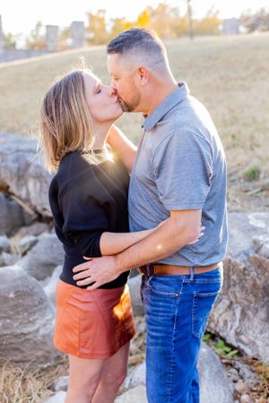 Romantic couple sharing intimate moment on rocky terrain during sunset in Springfield, MO.
