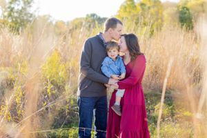 A tender family moment captured in a field of golden grass during sunset in Springfield, MO.
