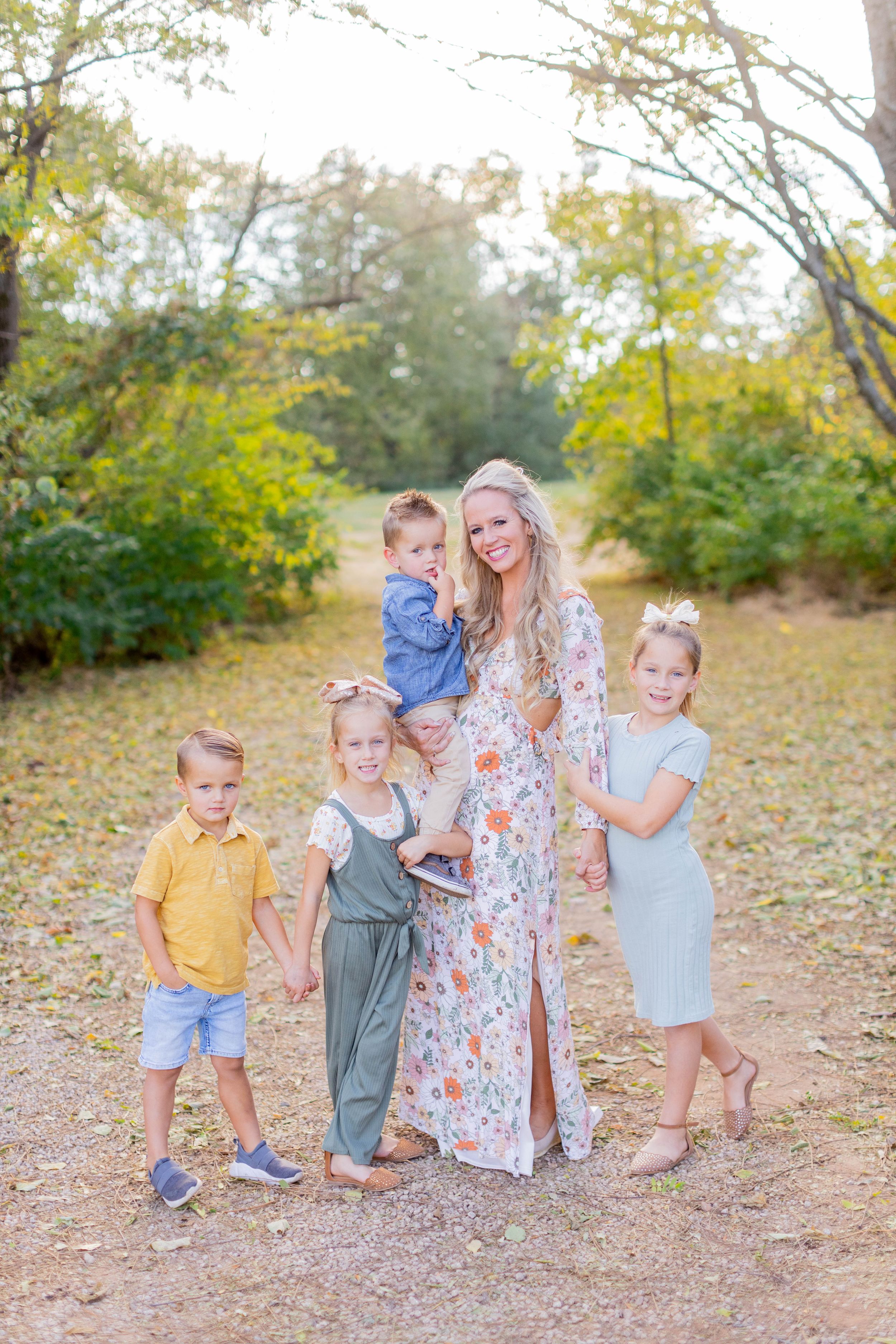 Family group poses together on woodland path during fall season in Springfield, MO.
