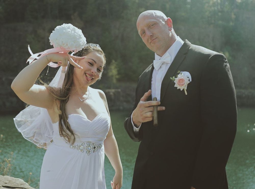 Wedding couple sharing intimate moments during outdoor photo session near water.