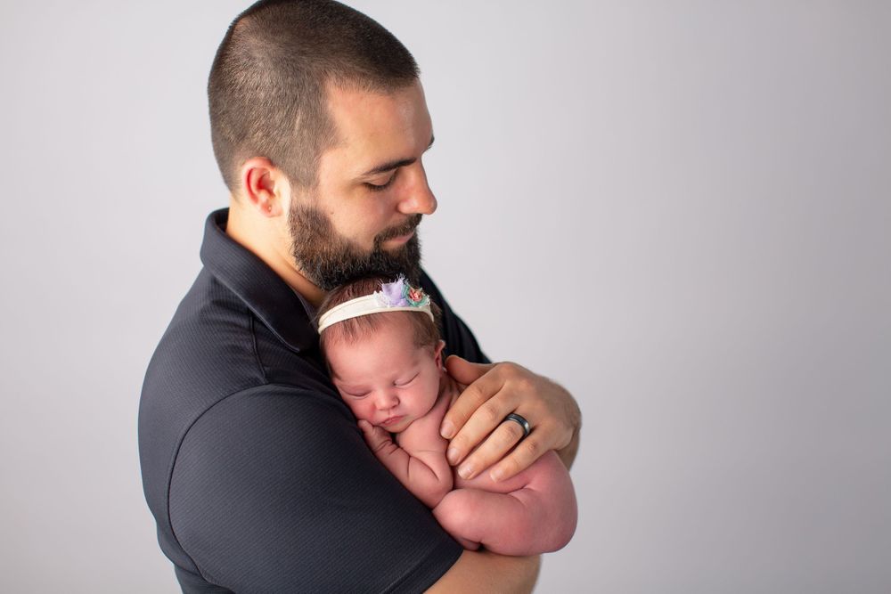 Gentle moment between parent and newborn during professional portrait session.