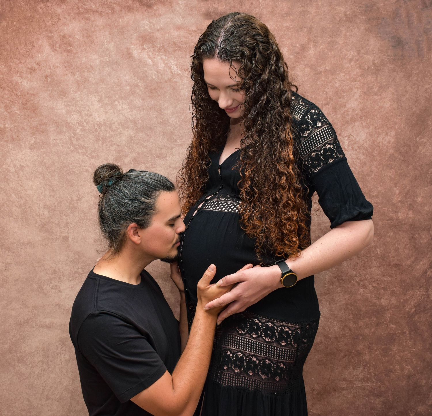 Intimate family portrait series with dramatic lighting against textured background.