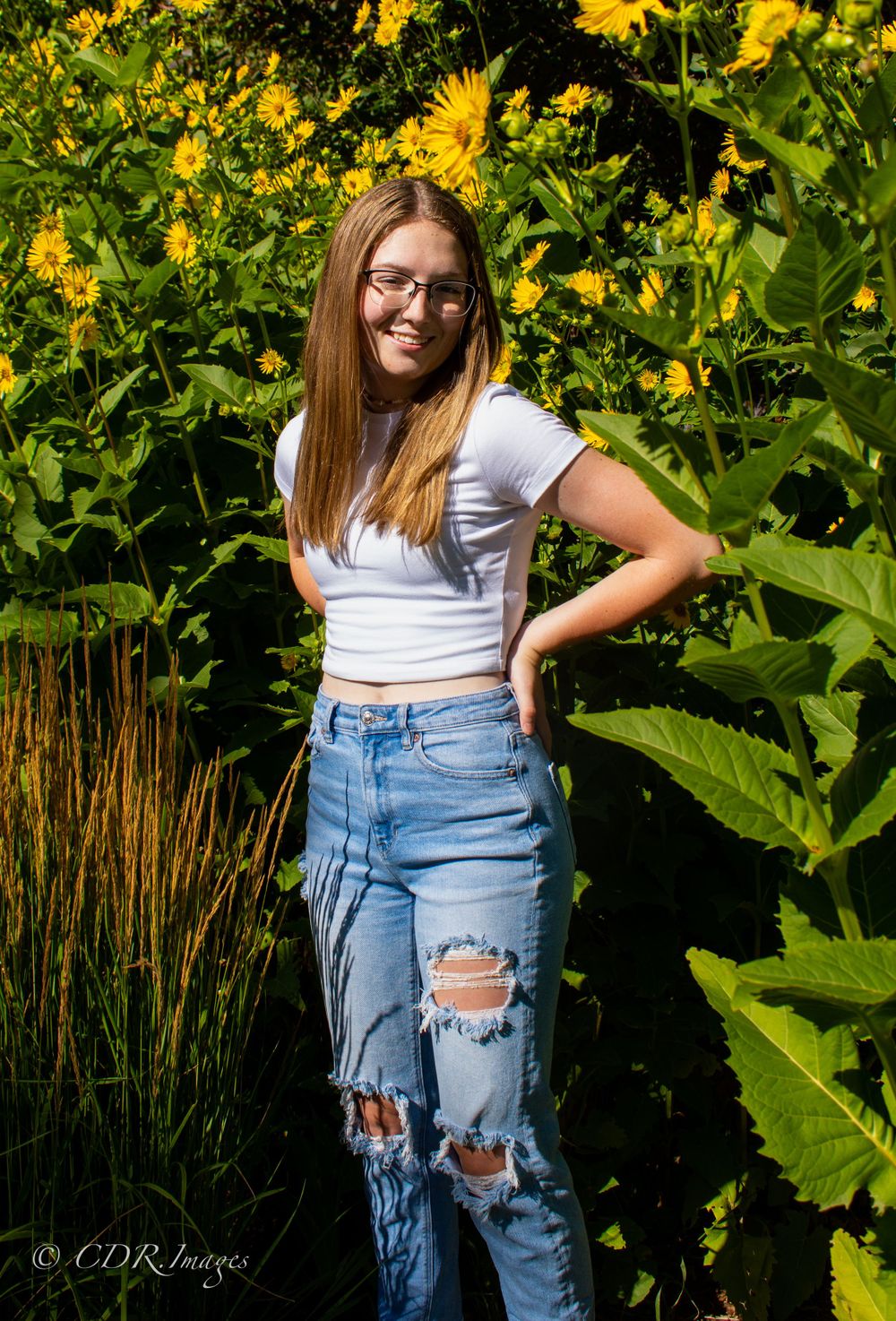 Summer portrait with bright yellow sunflowers and casual denim style.