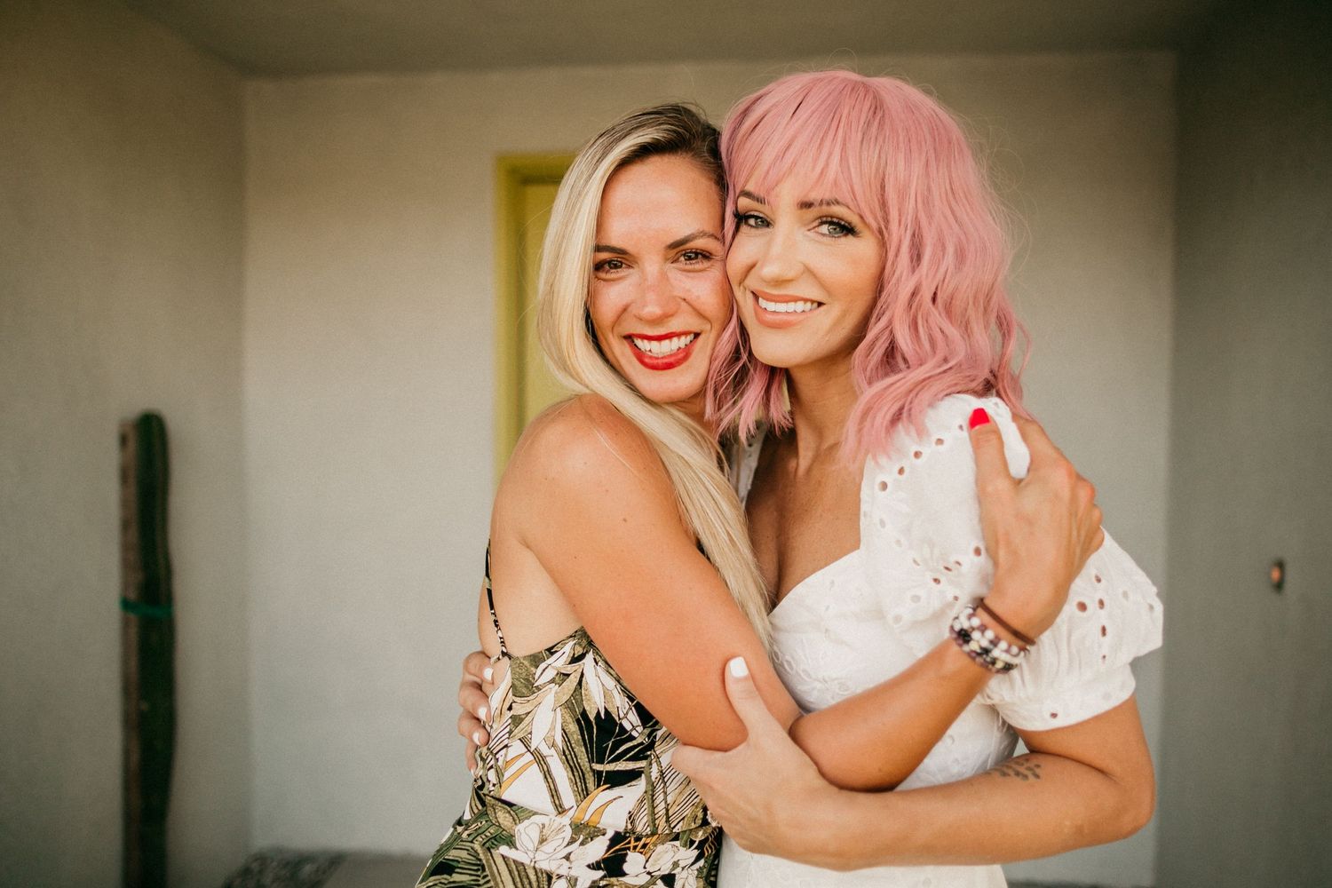 Two friends sharing a joyful embrace indoors.