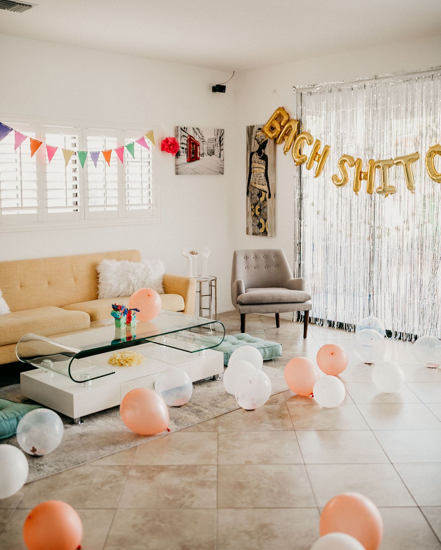 A decorated room with balloons, bunting, and gold letter balloons spelling out a phrase.