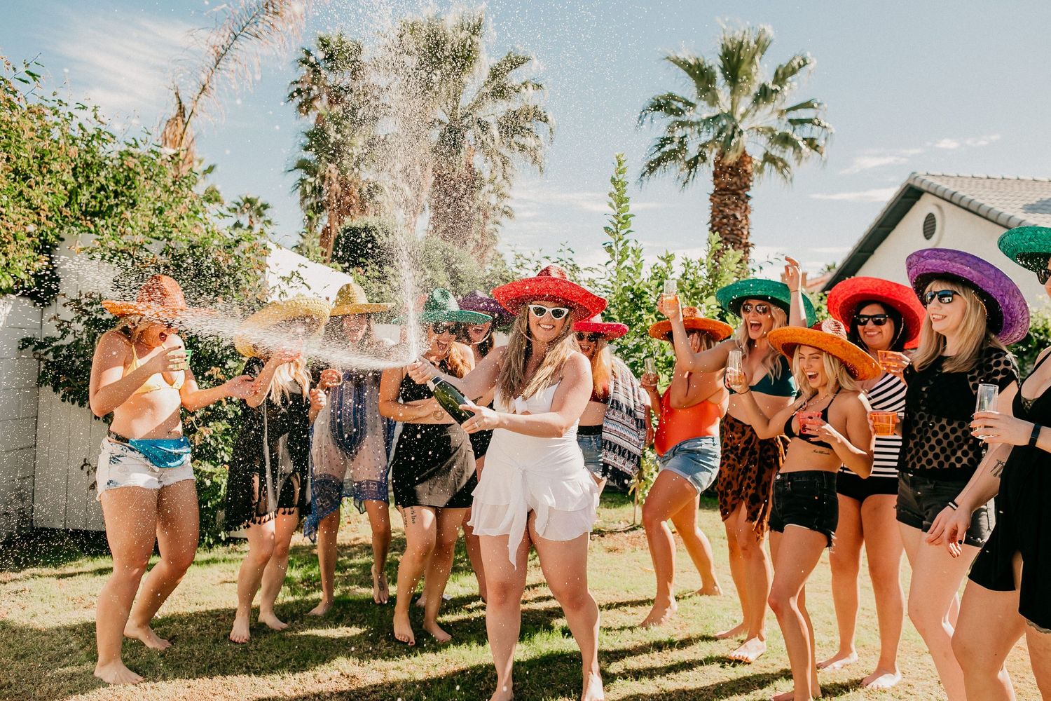 Outdoor summer party scene with people celebrating and spraying water.