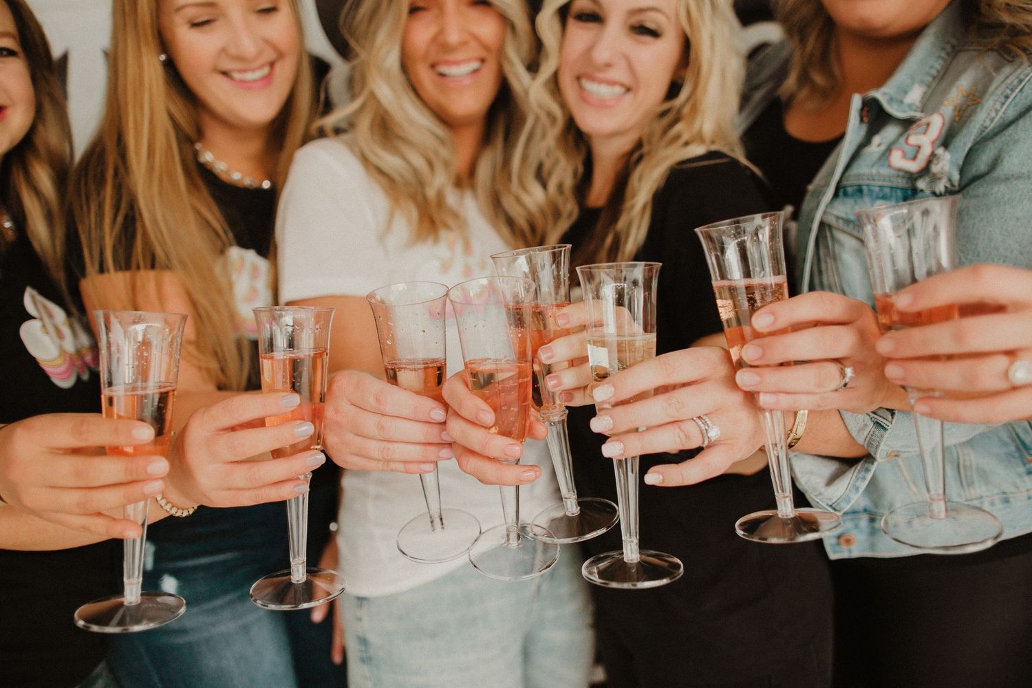 Friends toasting with champagne glasses in warm lighting.