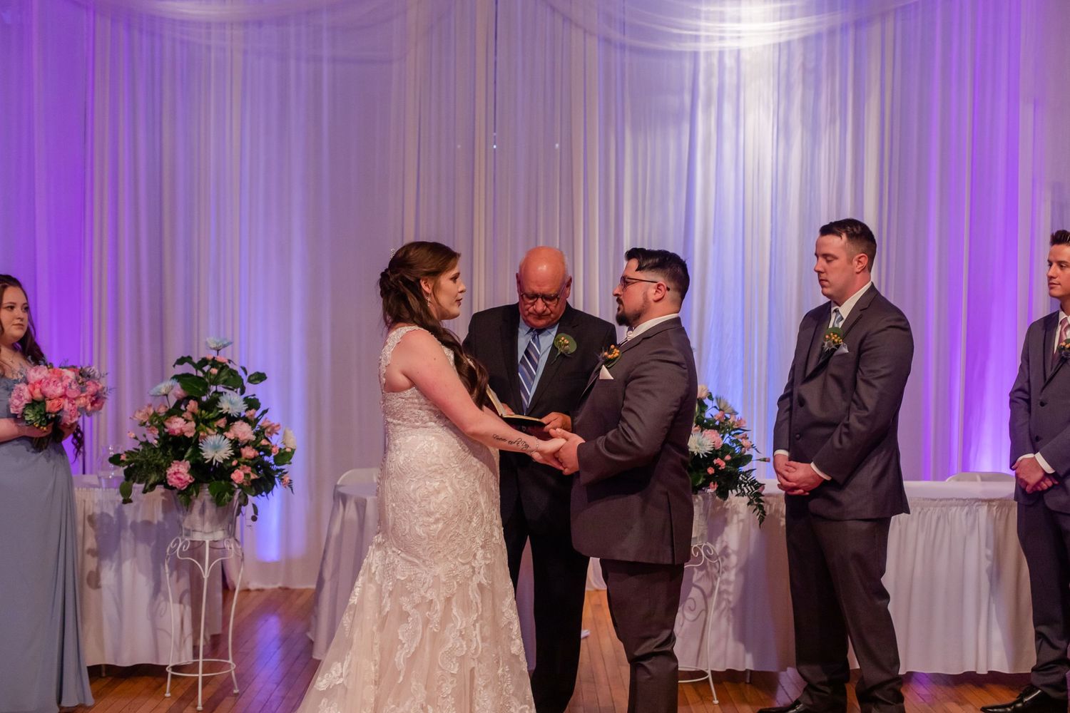 Wedding ceremony sequence showing special moments against purple-lit white drapes.