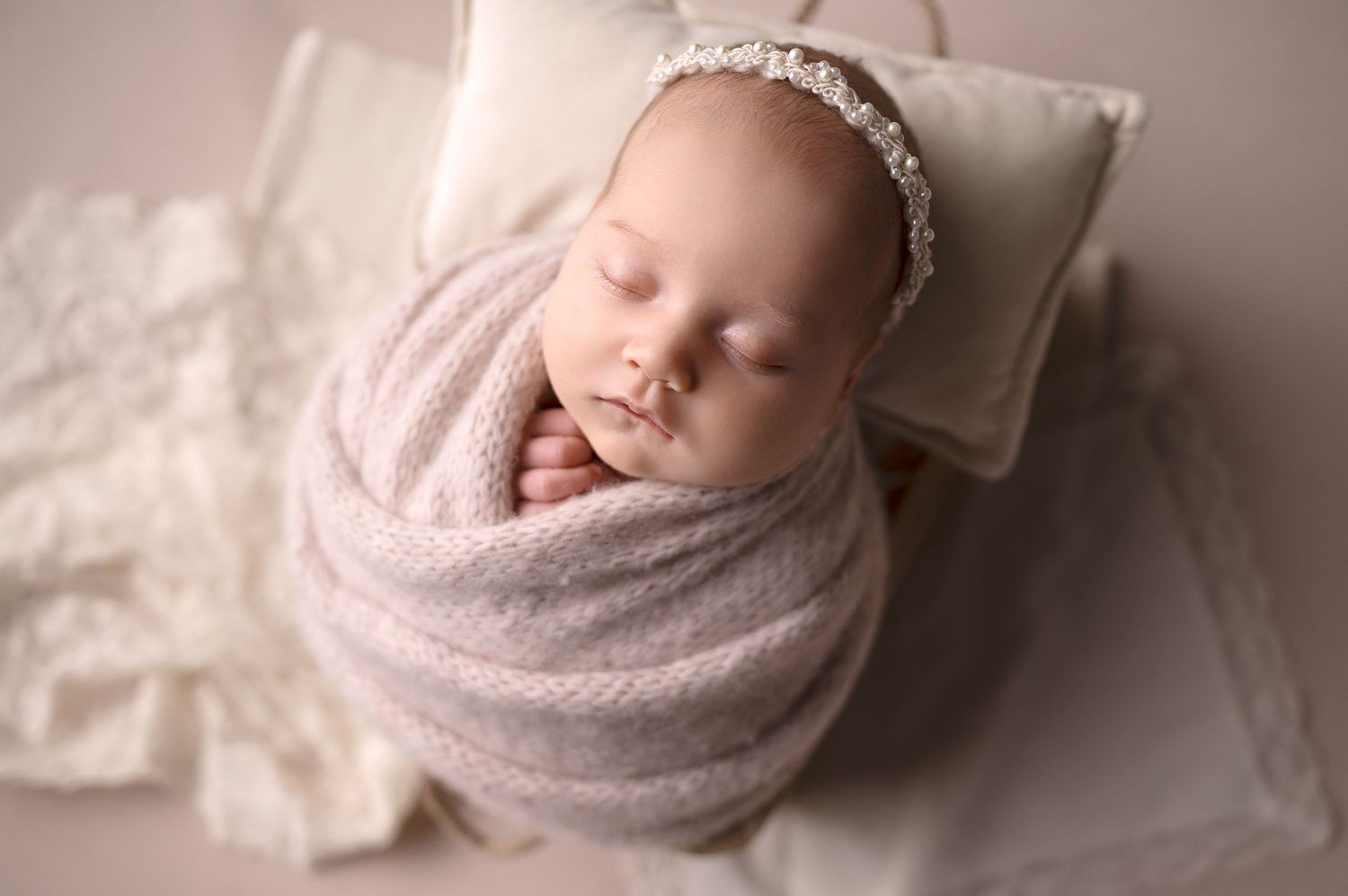 Soft and dreamy newborn photography session with muted pink tones.