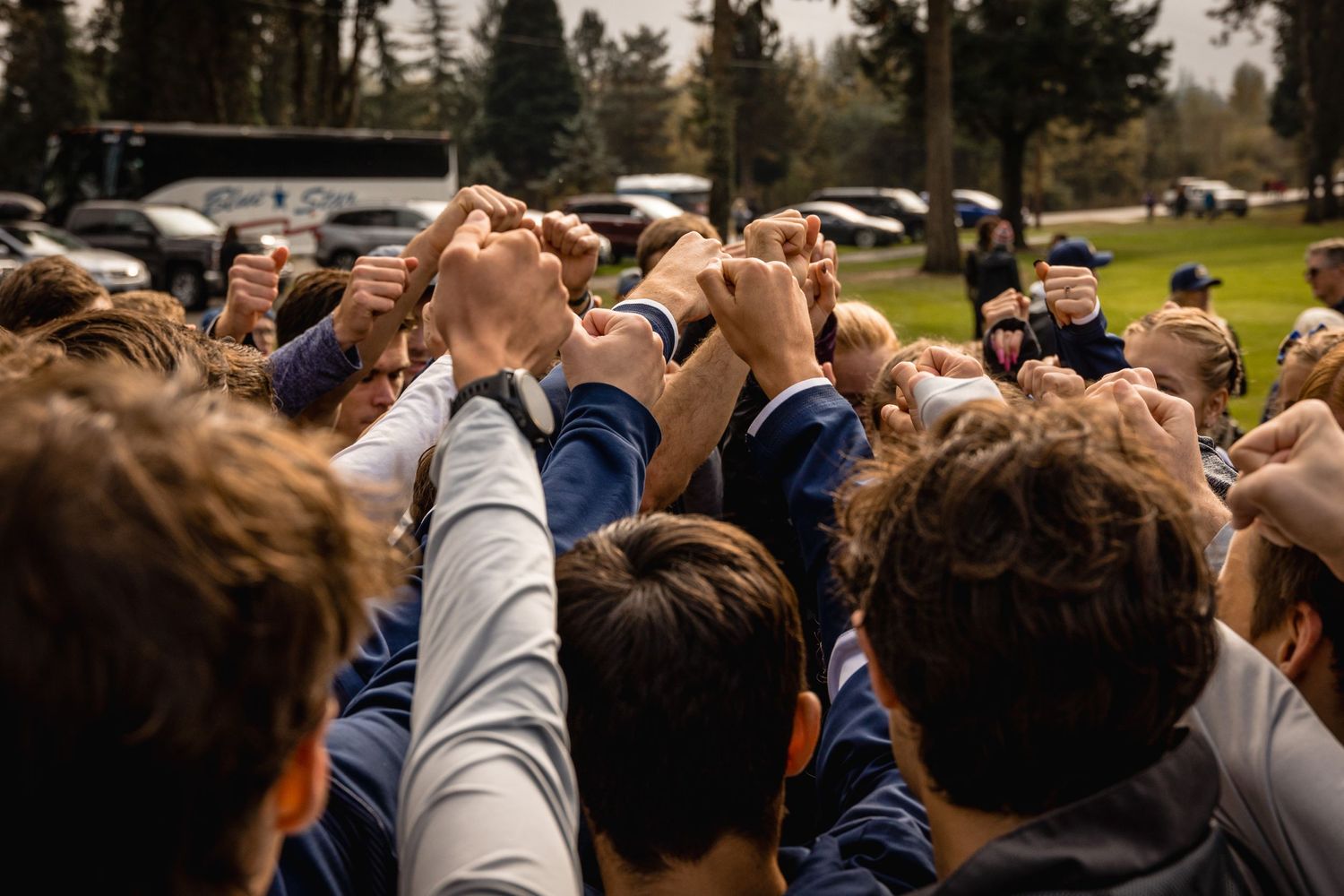 Athletes join hands in a team unity circle before their competition.