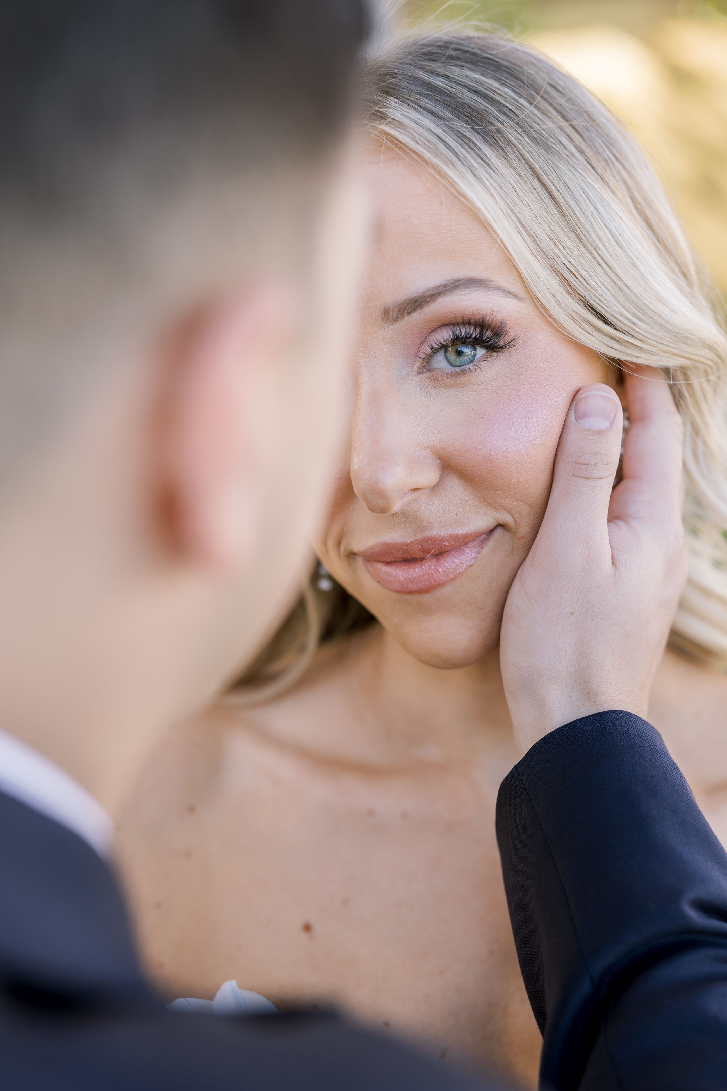 Intimate moment between couple during outdoor wedding photoshoot.