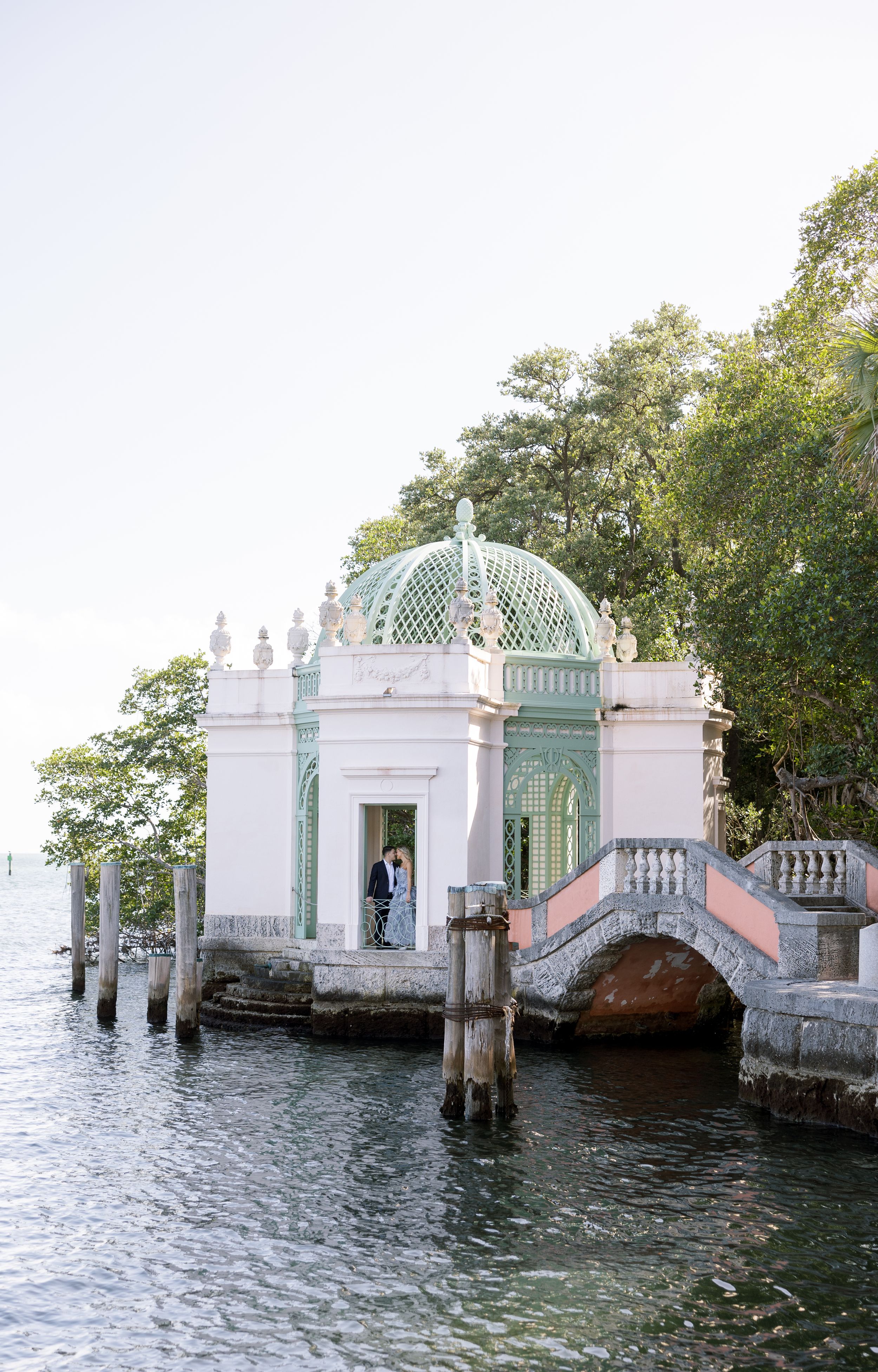 A white and mint green waterfront pavilion with decorative dome and classical architecture.